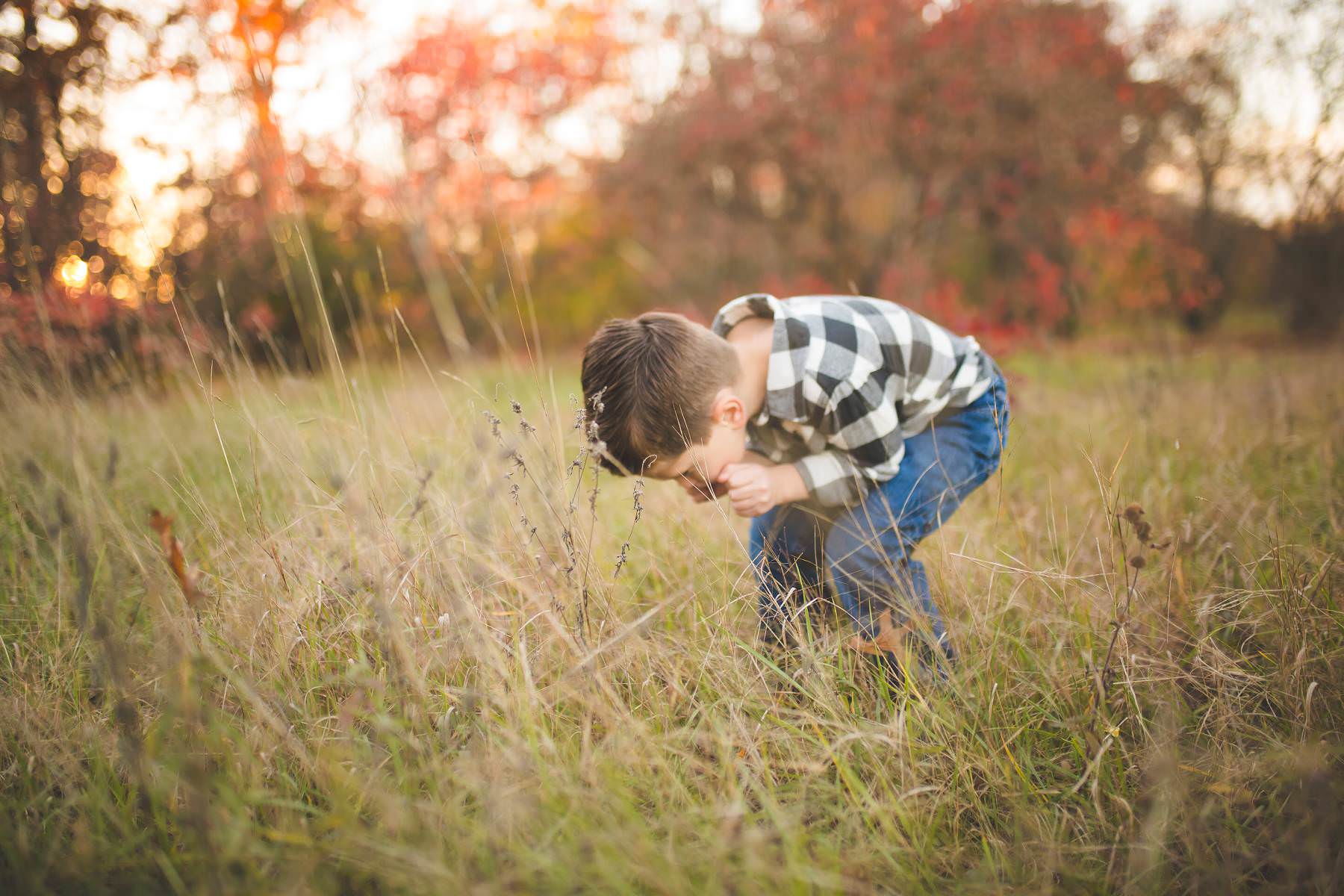 boy plays at sunset on old tree farm