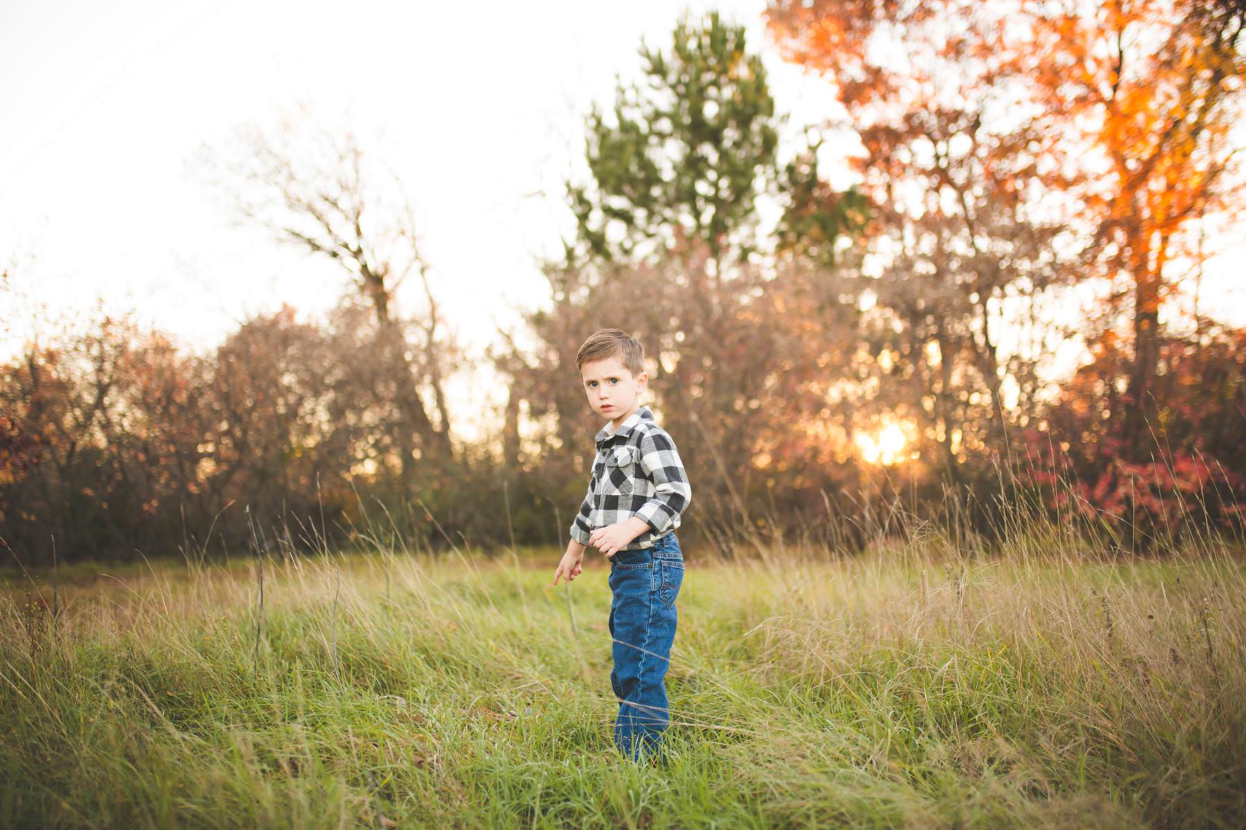 boy plays at sunset on old tree farm