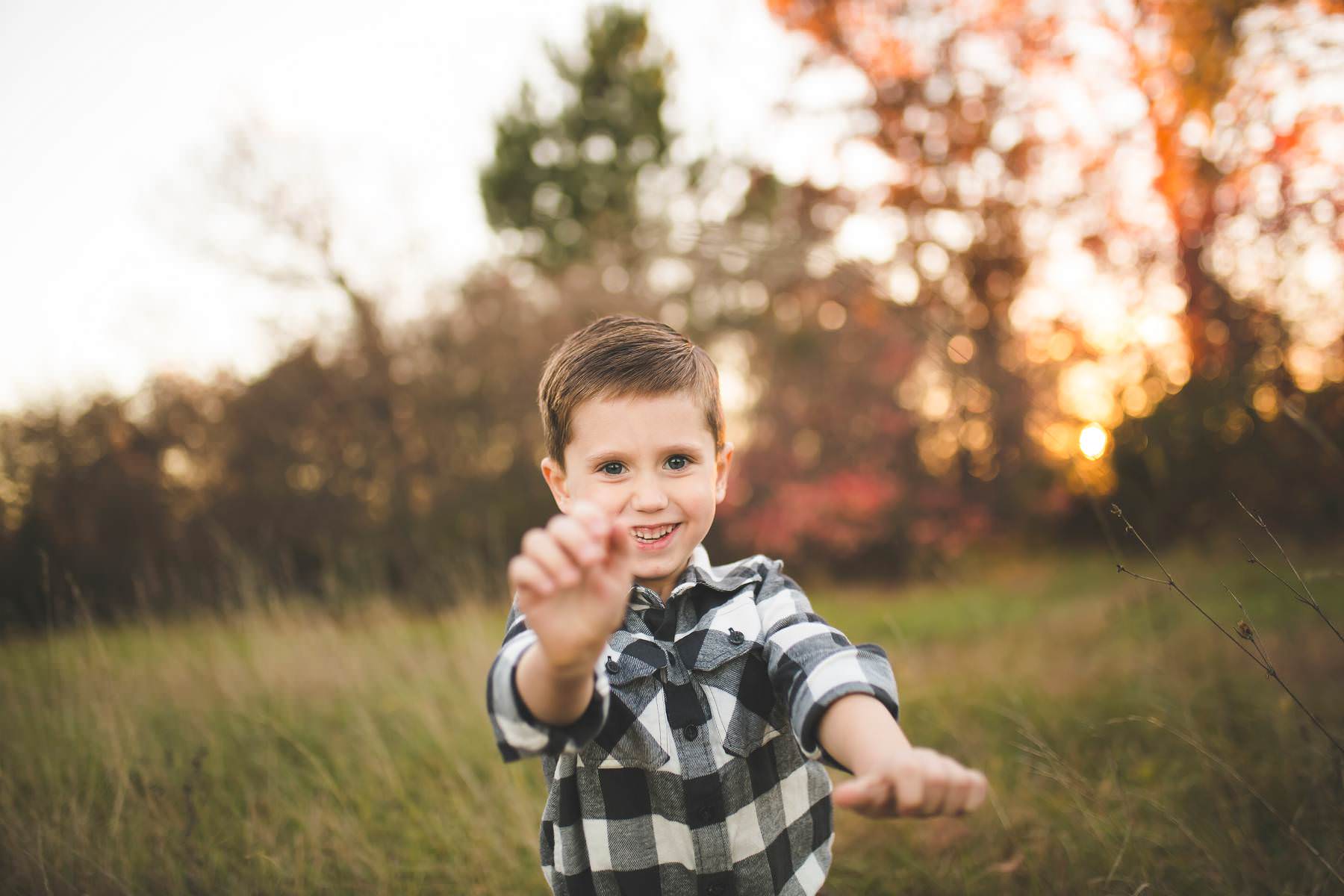 boy plays at sunset on old tree farm