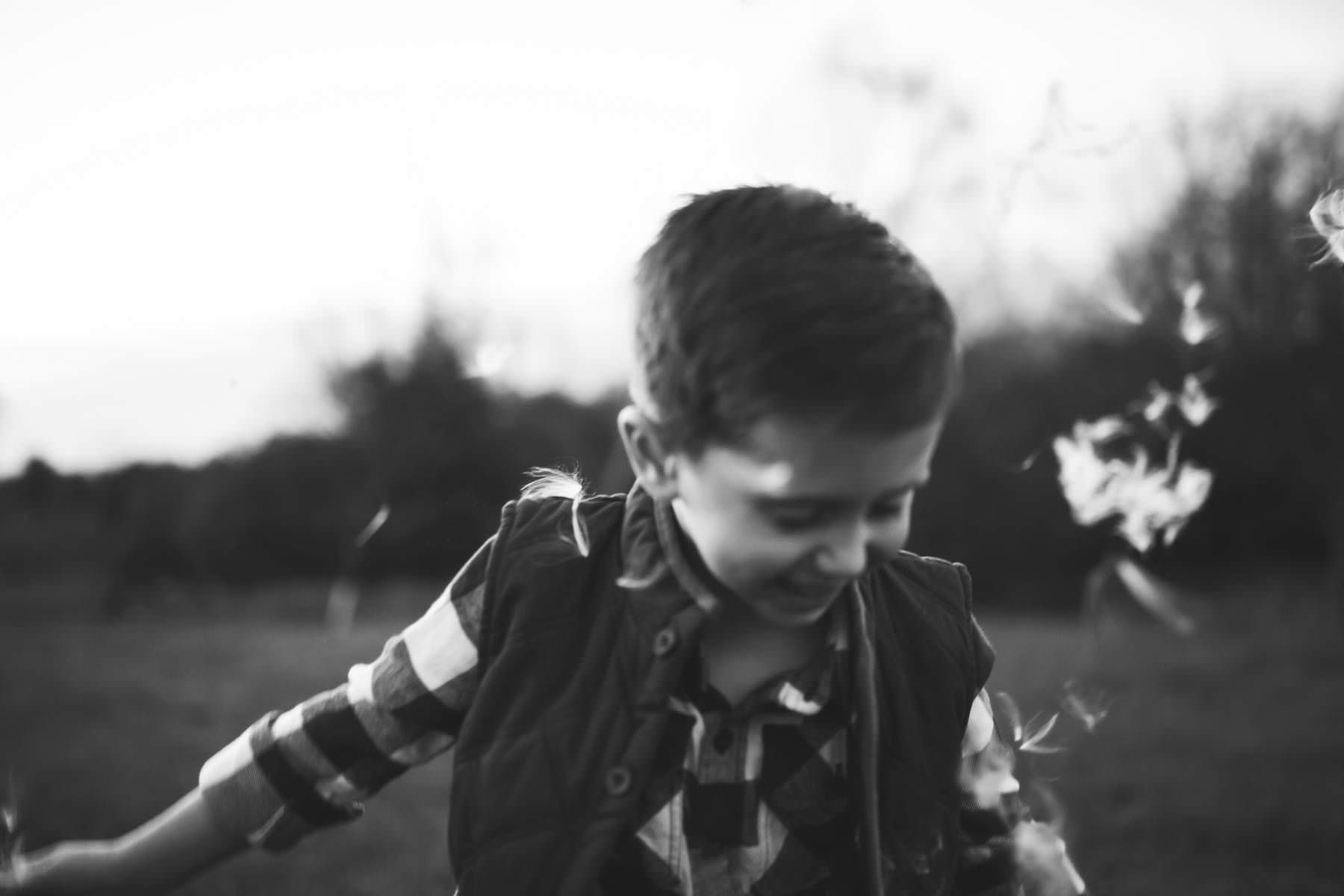 boy plays at sunset on old tree farm