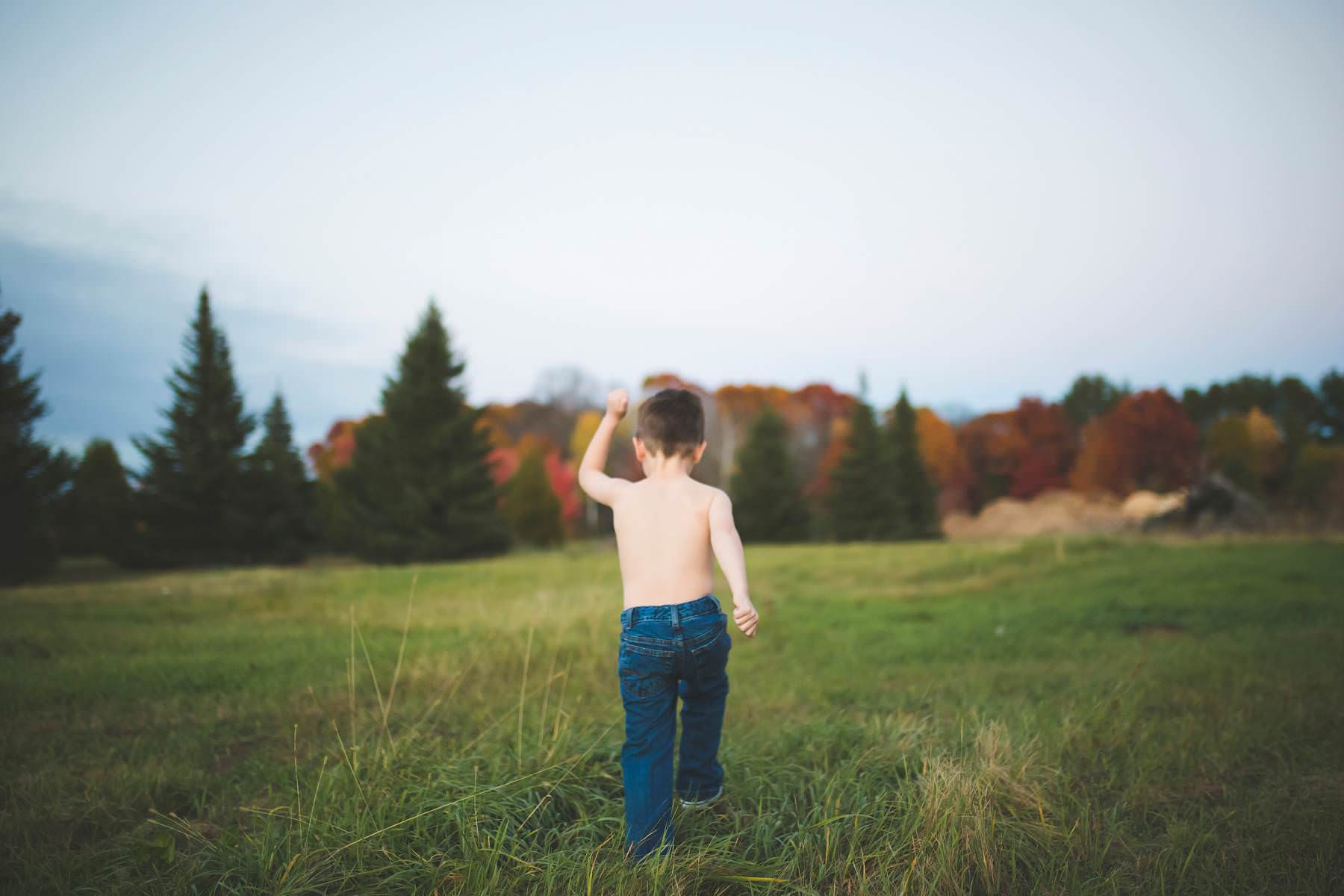 boy plays at sunset on old tree farm