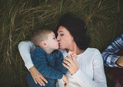 mom kisses son in patch of tall grass lake elmo