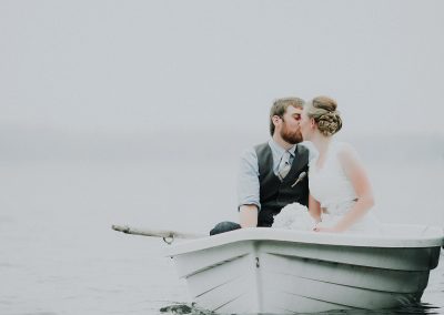bride and groom in row boat kissing minnesota