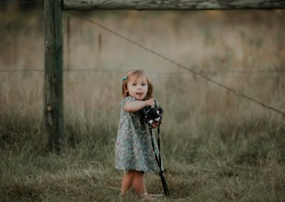 little girl in blue dress holding vintage camera