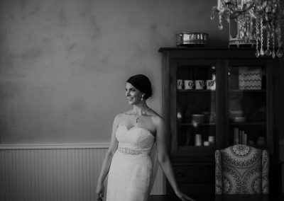 bride leaning against fancy desk in her wedding dress